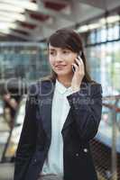 Businesswoman talking on mobile phone on platform