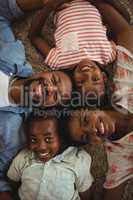 Portrait of happy parents and kids lying on rug