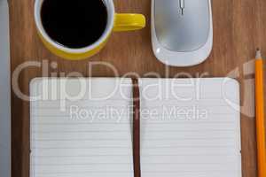 Cup of coffee with organizer, pencil and mouse