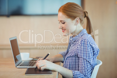 Female graphic designer using graphics tablet