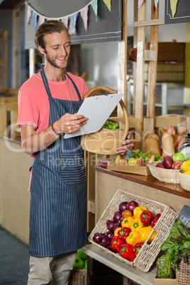 Male staff looking at clipboard in organic section