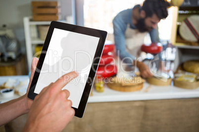 Staff using digital tablet at bakery counter