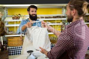 Customer receiving parcel at meat counter