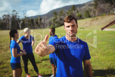 Fit man showing thumbs up in bootcamp