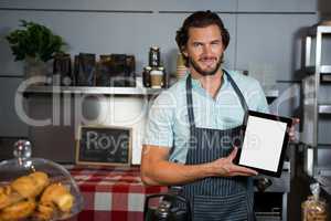 Male staff holding a digital tablet in coffee shop