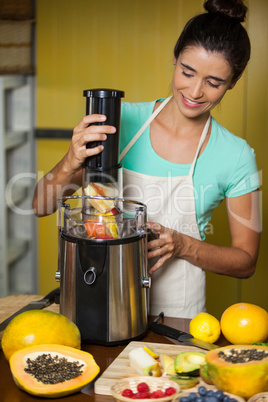 Smiling shop assistant preparing juice