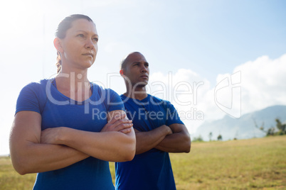 Female trainer and male trainer standing with arms crossed