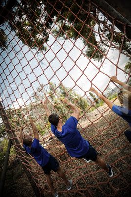 People climbing a net during obstacle course