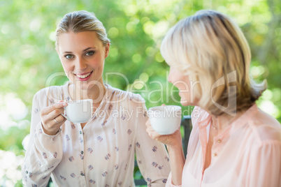 Smiling friends enjoying coffee together