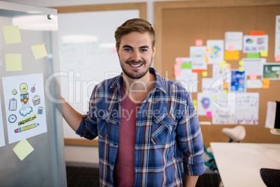 Smiling man standing near the wall with sticky notes