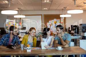 Creative business team discussing over digital tablet at desk