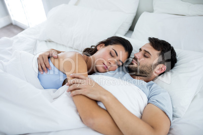 Young romantic couple sleeping on bed