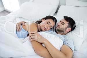Young romantic couple sleeping on bed