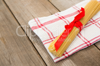 Bundle of raw spaghetti tied with red ribbon
