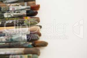 Various dirty paintbrushes arranged in a row