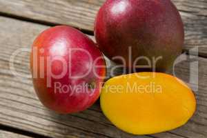 Halved mangoes on wooden table