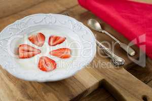 Slices of strawberries in plate with spoon