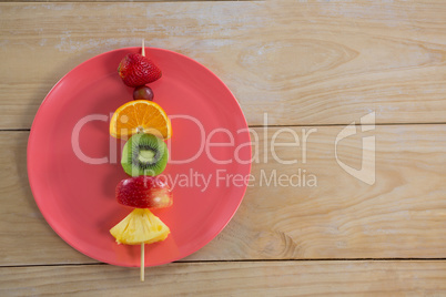 Overhead of fruit skewers in plate