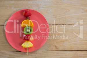Overhead of fruit skewers in plate