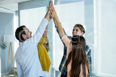 Creative business team giving a high five to each other