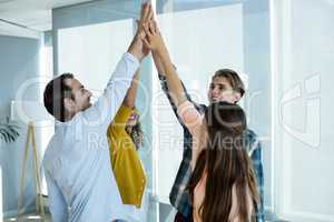 Creative business team giving a high five to each other