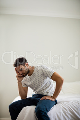 Worried man sitting in the bedroom