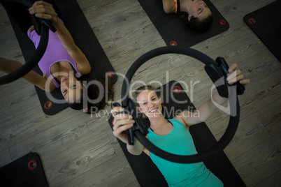 Fit woman exercising with pilates ring