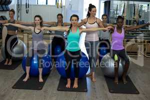 Female trainer assisting woman with exercise