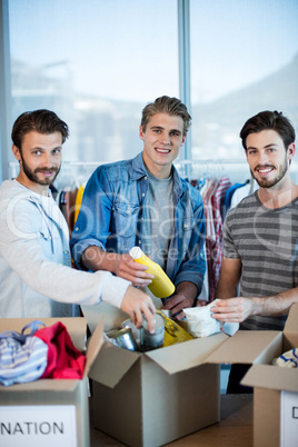 Creative business team sorting clothes in donation box