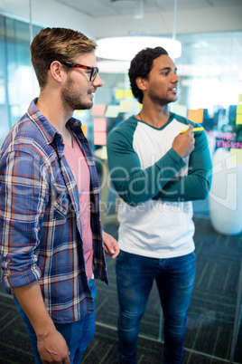 Creative business team standing against the wall with sticky notes