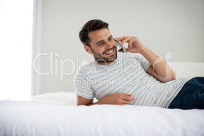 Man talking on mobile phone in bedroom