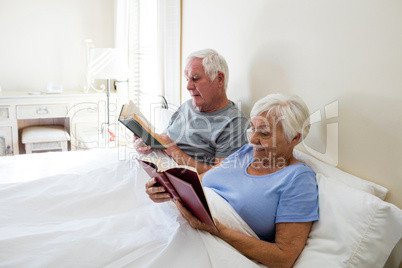 Senior couple reading books in the bedroom