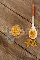 Conchiglie pasta spilling out of jar and spoon