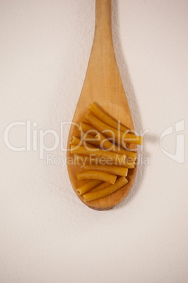 Pennette pasta in wooden spoon