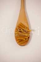 Pennette pasta in wooden spoon