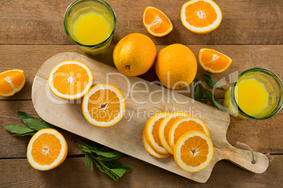 Overhead of oranges with glasses of juice