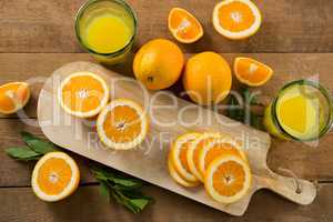 Overhead of oranges with glasses of juice