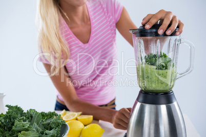 Woman preparing vegetable smoothie