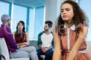 Woman crying while creative business team in background
