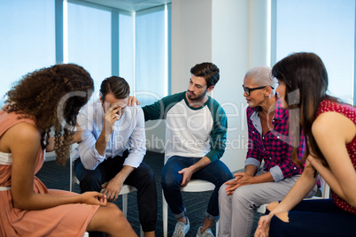 Creative business team consoling upset colleague