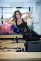 Portrait of woman practicing stretching exercise on reformer