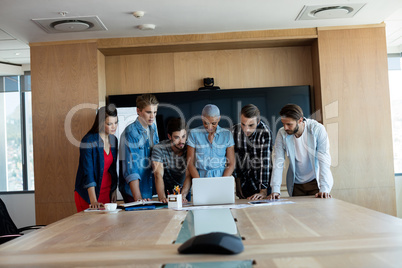 Creative business team looking at presentation in laptop