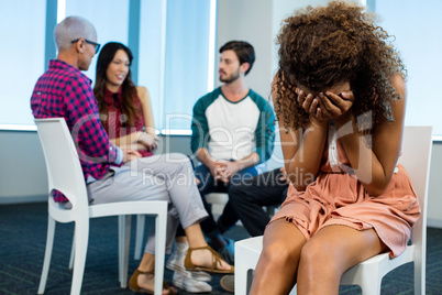 Woman crying while creative business team in background