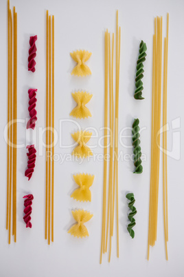 Multicolored pasta arranged on white background