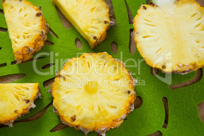 Close-up of slices and halved pineapple in tray