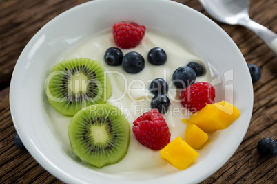 Close-up of various fruits in plate with spoon