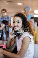 Woman with headphones working with her team in office