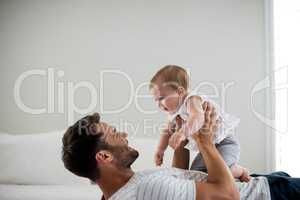 Father playing with his baby in bedroom