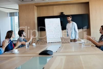 Creative business team applauding while attending a presentation