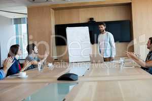 Creative business team applauding while attending a presentation